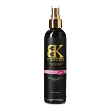 An image of a black round-topped bottle of Seduce Me pheromone enhanced body mist on a white background. The bottle has a gold pump-spray cap. The label reads French Kiss on a pink strip.